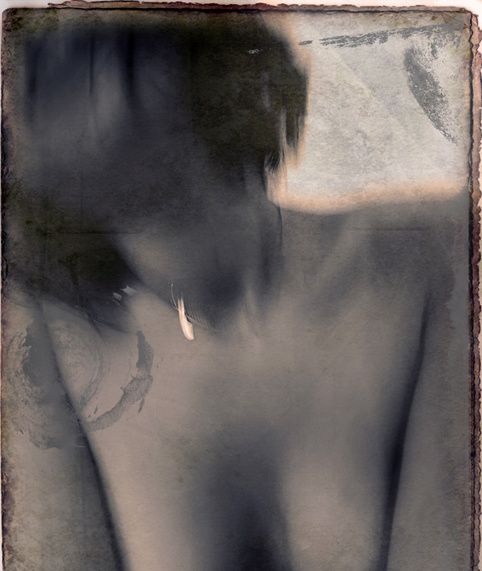 A woman's bare shoulders and chest, her face blurred and turned away, in muted blue-grey on a weathered print.