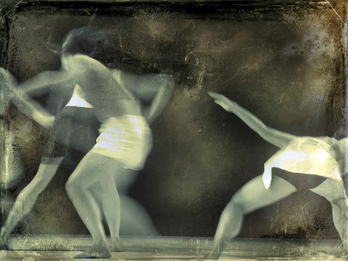 Two pale dancers blurred in motion against a dark weathered ground.