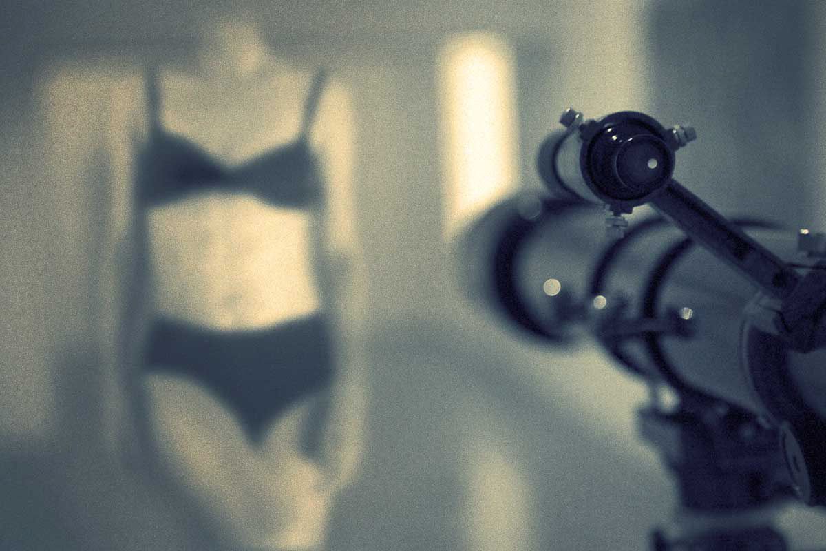 A blurred woman in underwear beside a telescope, in cool tones.